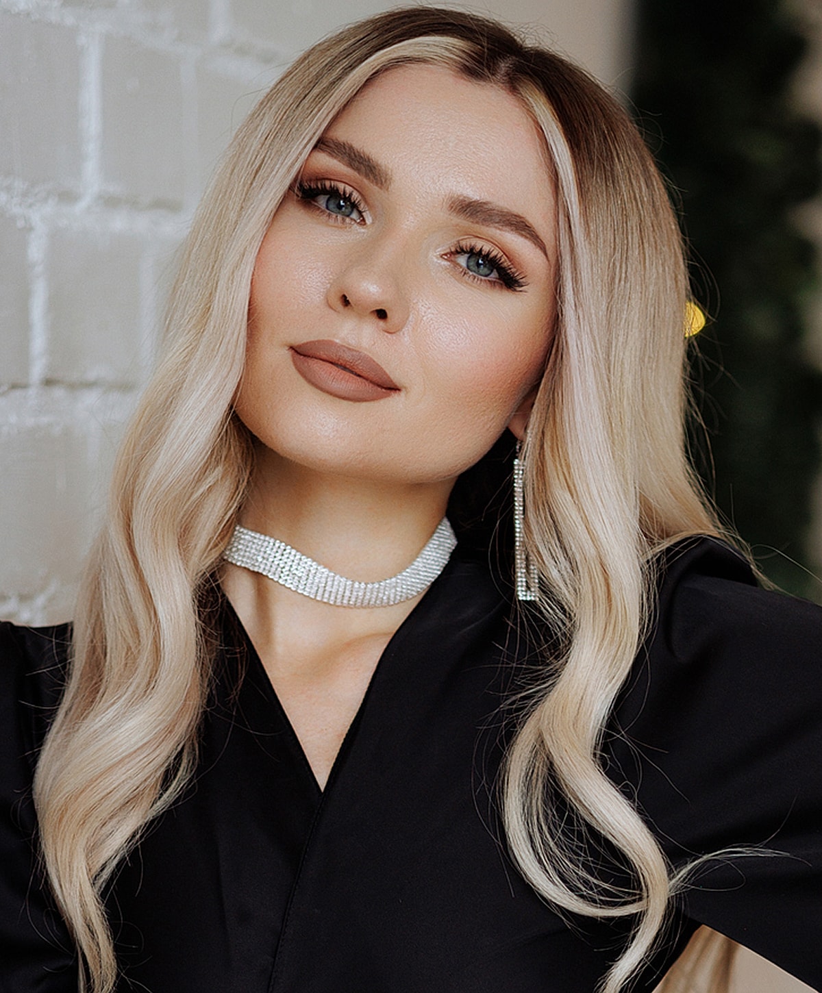 Blonde woman with elegant makeup and accessories.