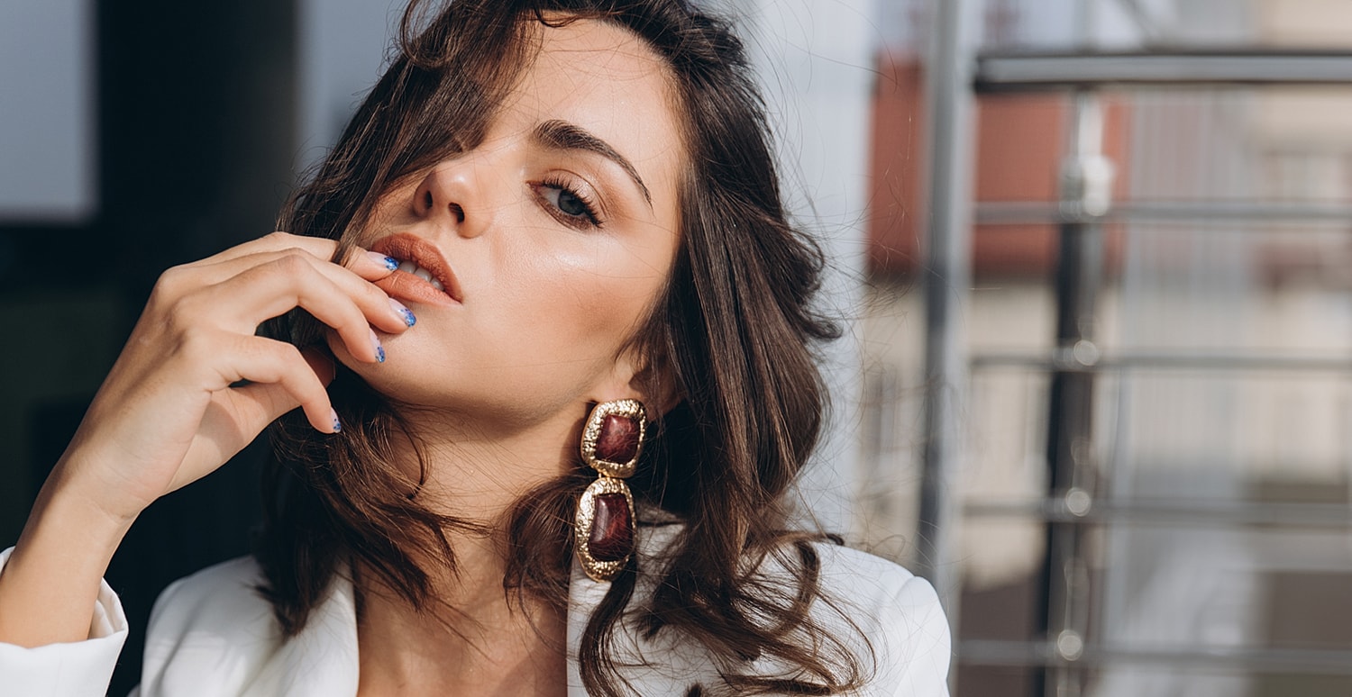 Woman with stylish earrings and glamorous makeup.