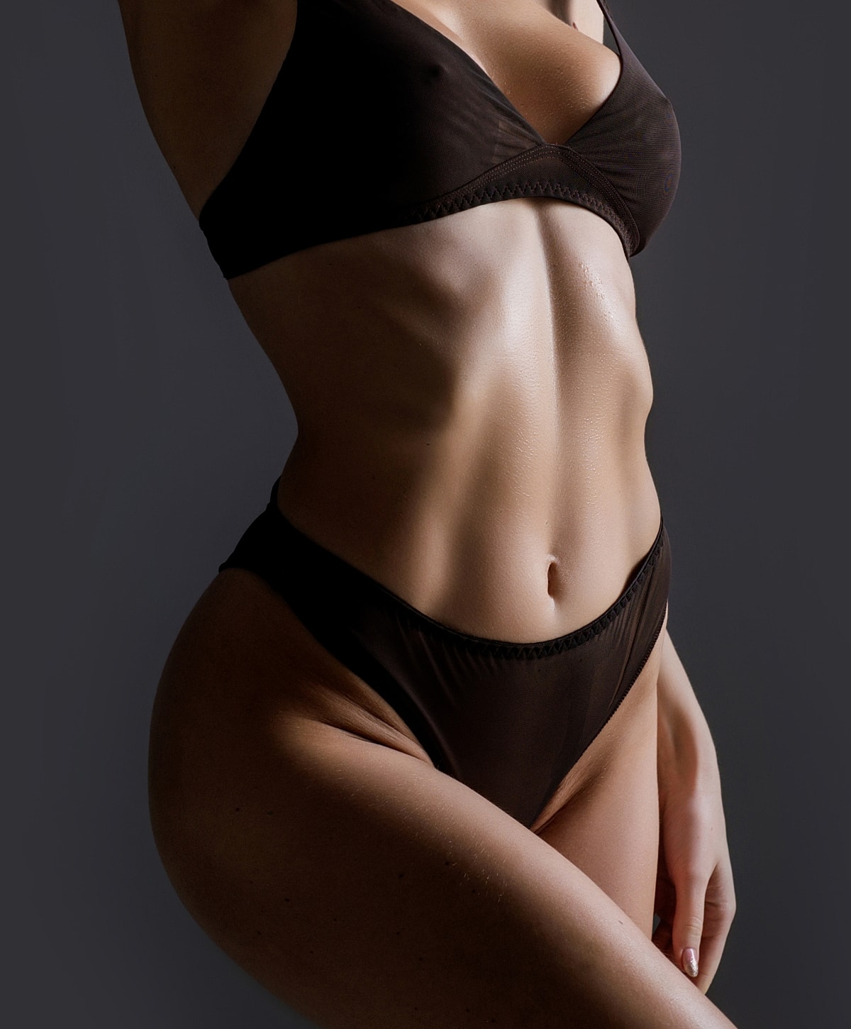 Model in dark lingerie posing elegantly.