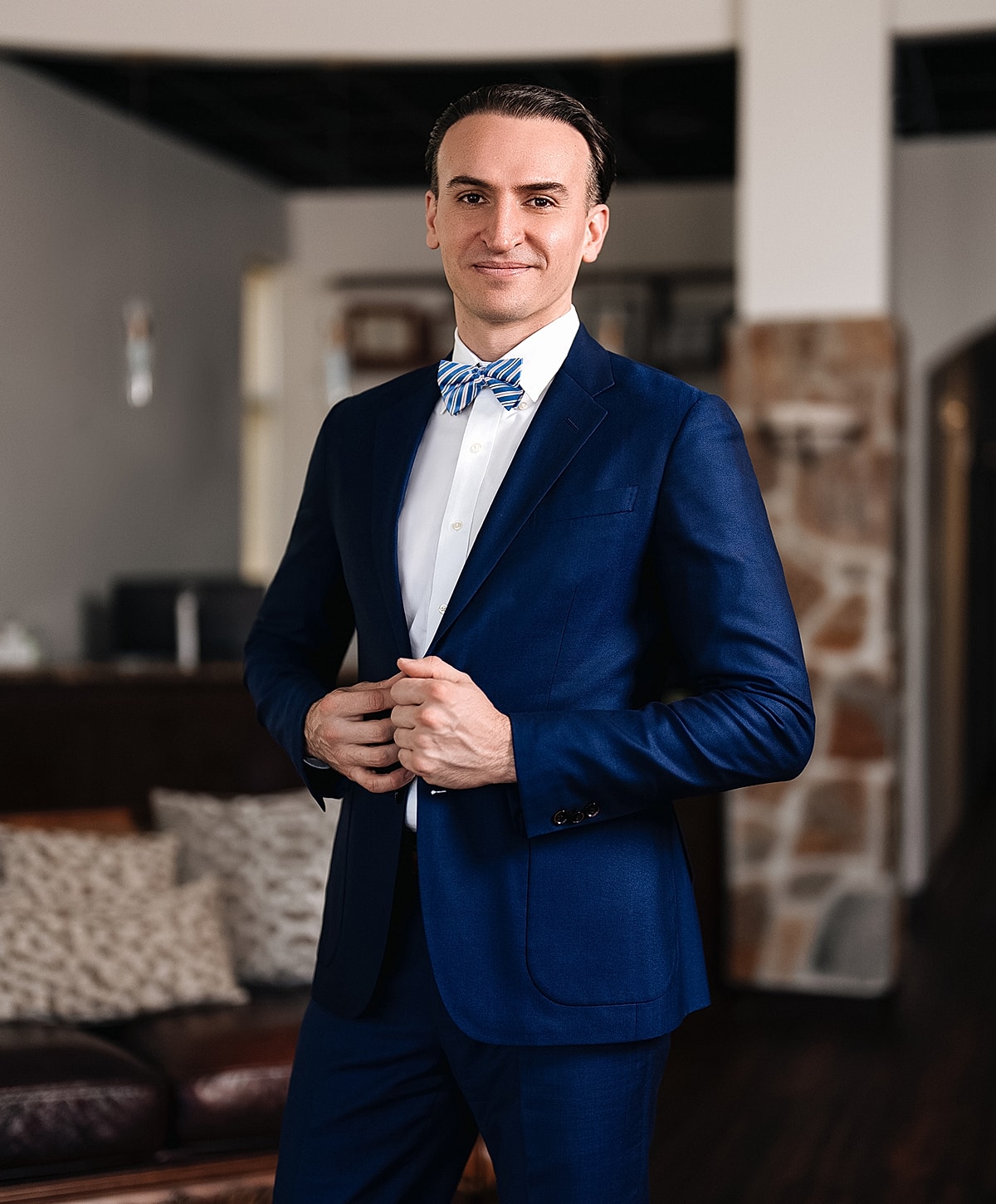 Man in suit and bow tie, stylish pose.