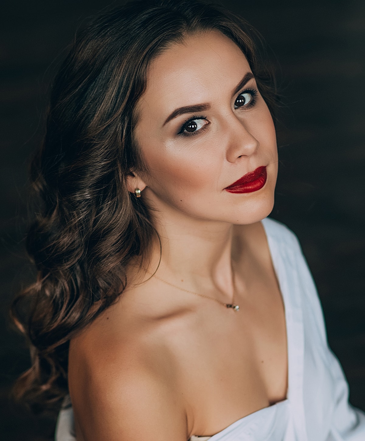 Model in white lingerie and thigh-high stockings.