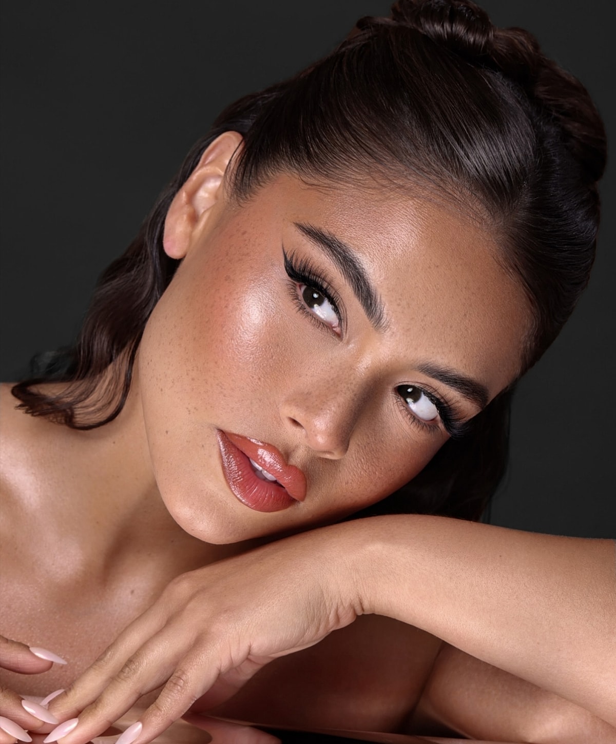 Woman with glamorous makeup and soft expression.