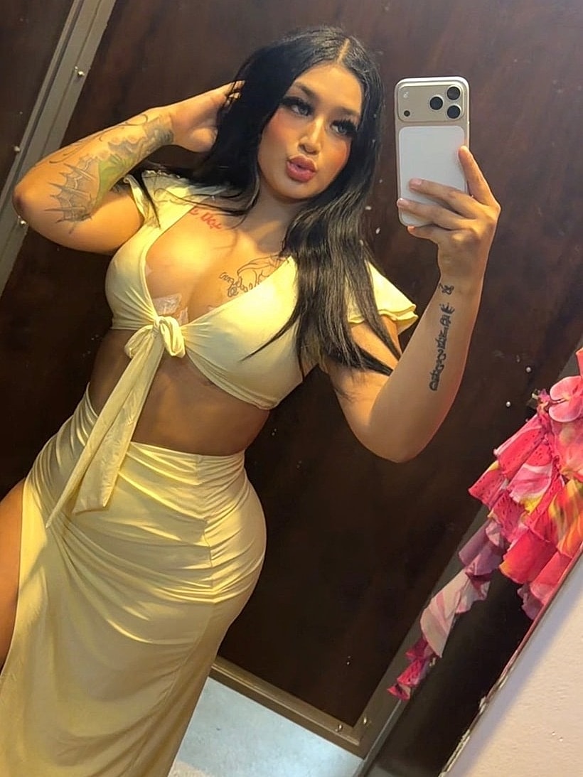 Person posing in mirror wearing stylish outfit.