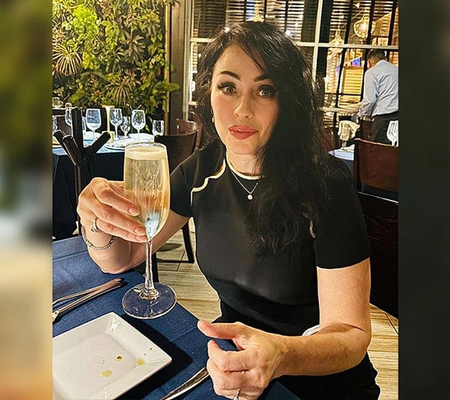 Woman toasting with champagne in restaurant setting.