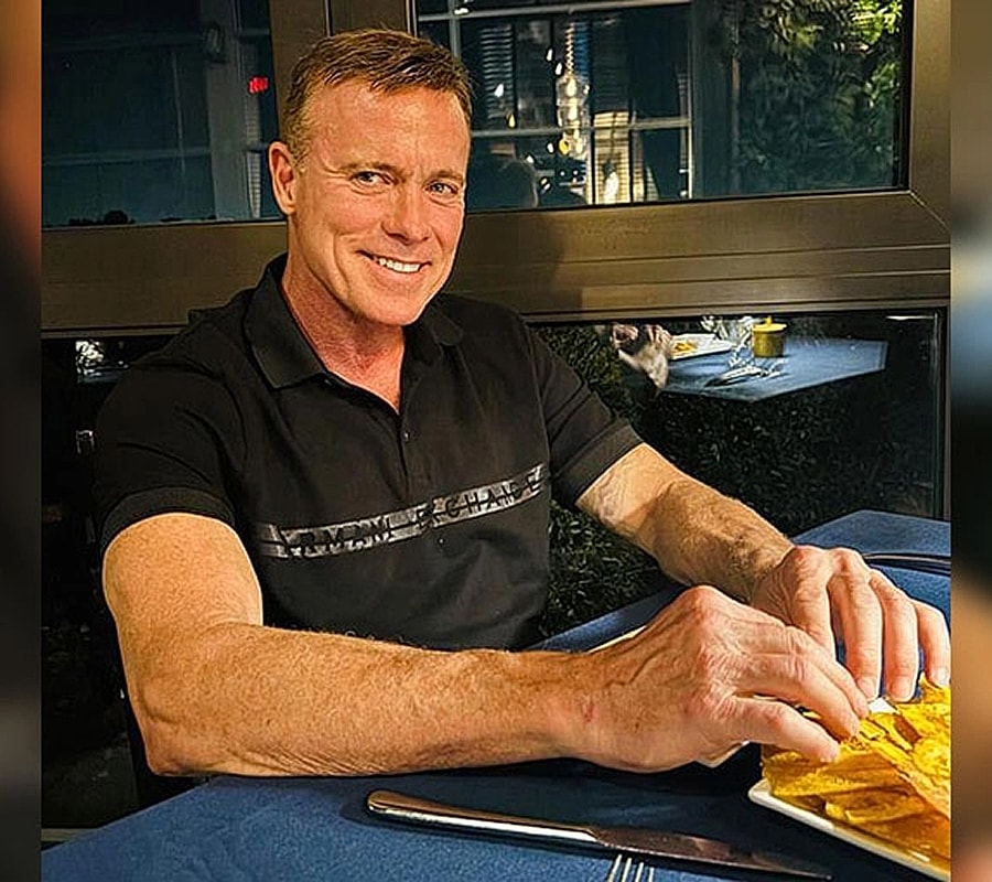 Man enjoying food at a table with bluecloth.