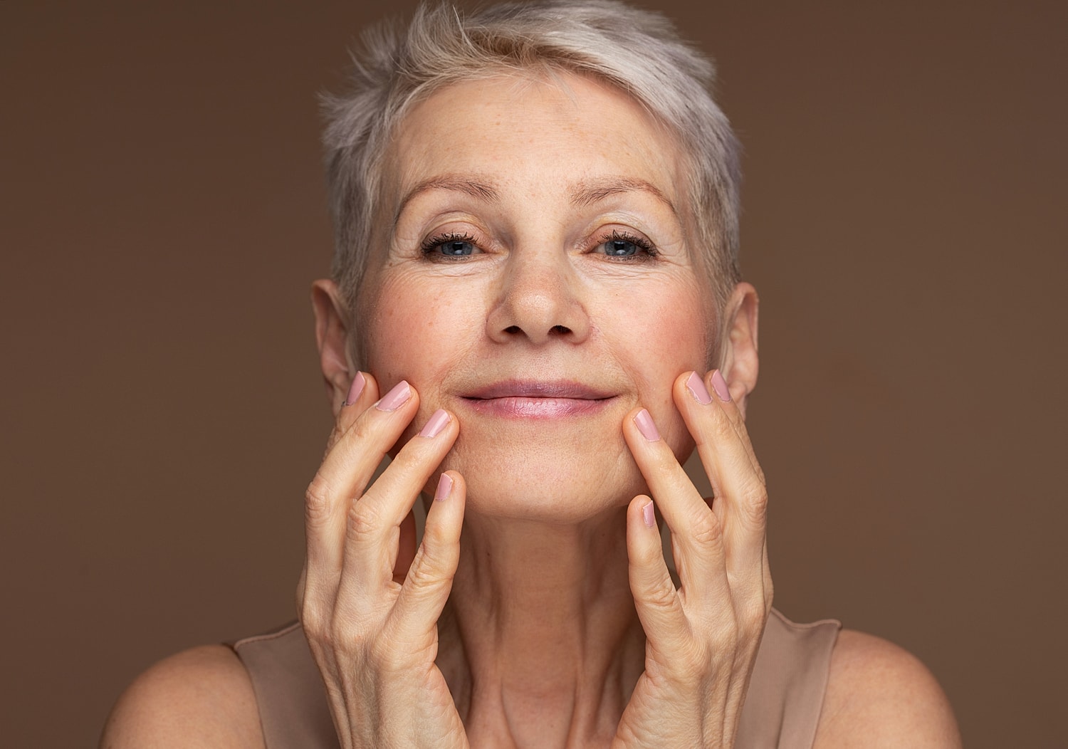 Smiling woman gently touching her face