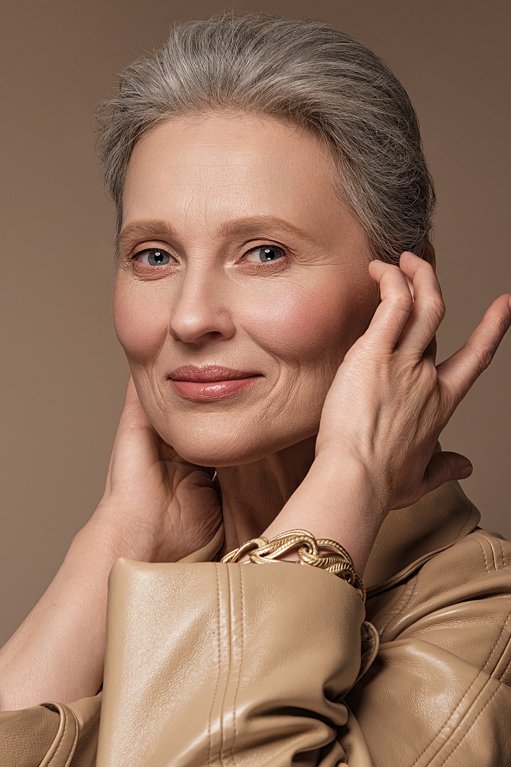Elegant older woman with silver hair, posing gracefully.