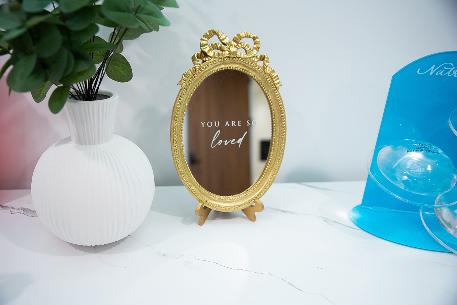 Gold mirror with "you are so loved" inscription.