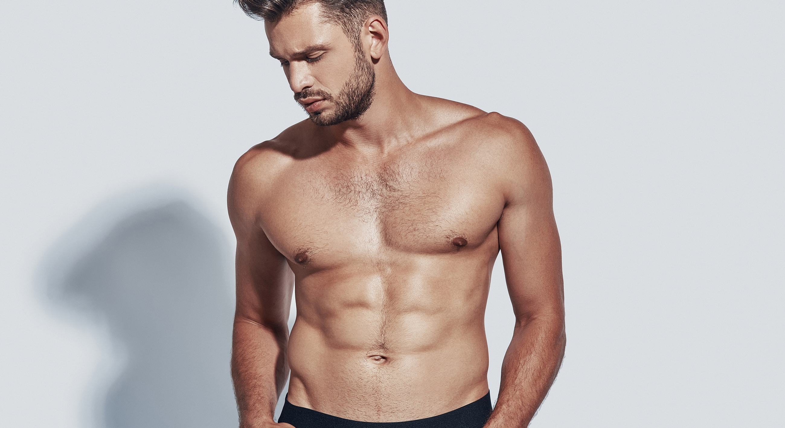 Shirtless man showing toned physique and abs.