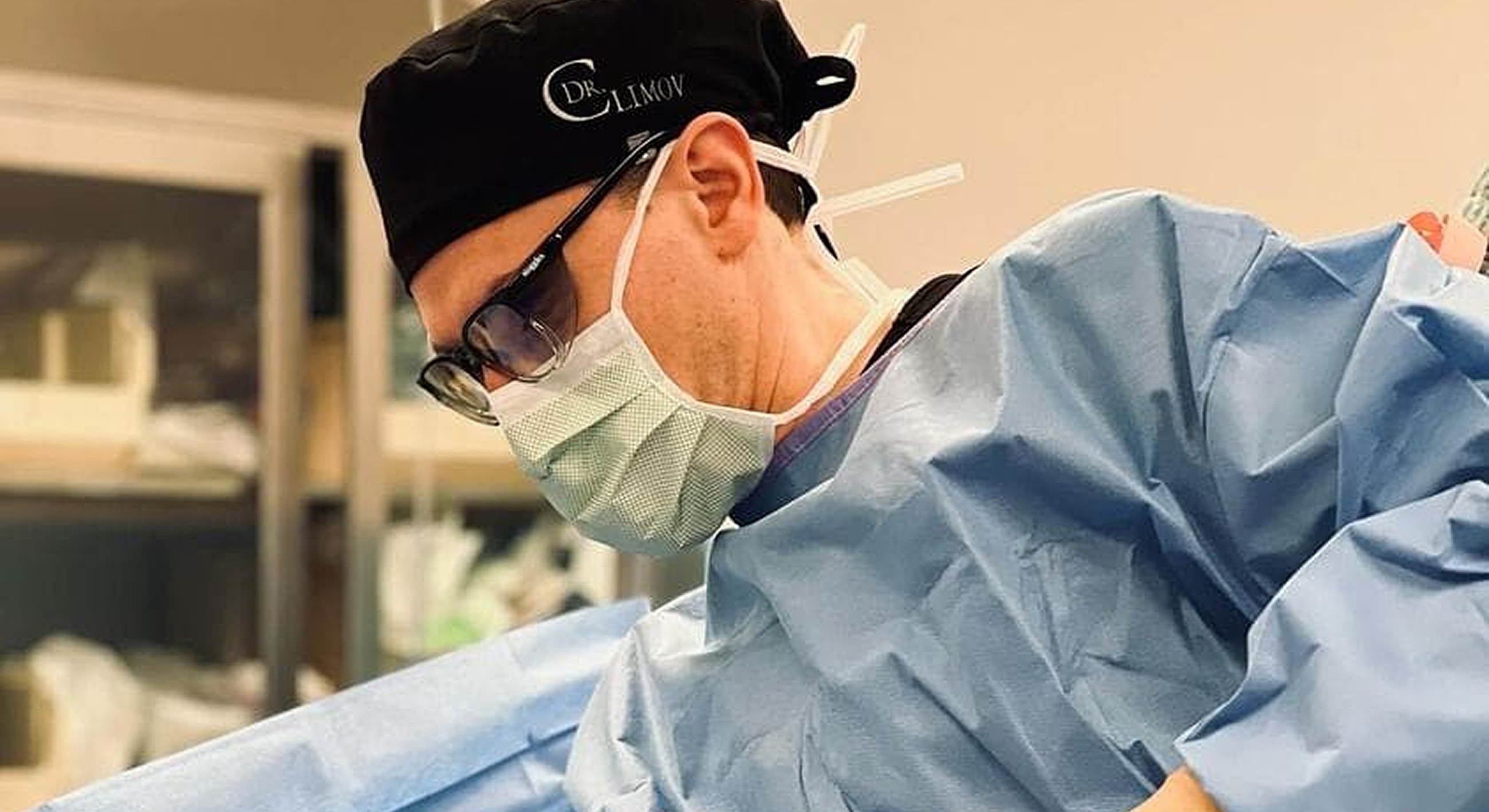 Male clinician in black scrubs, smiling confidently.