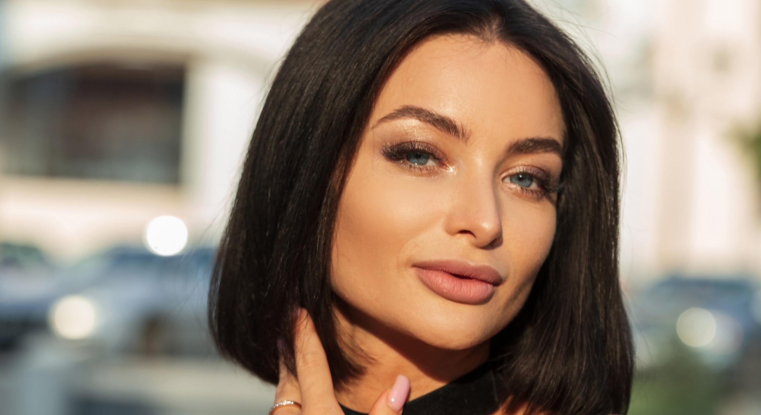 Woman with dark bob hairstyle and natural makeup.