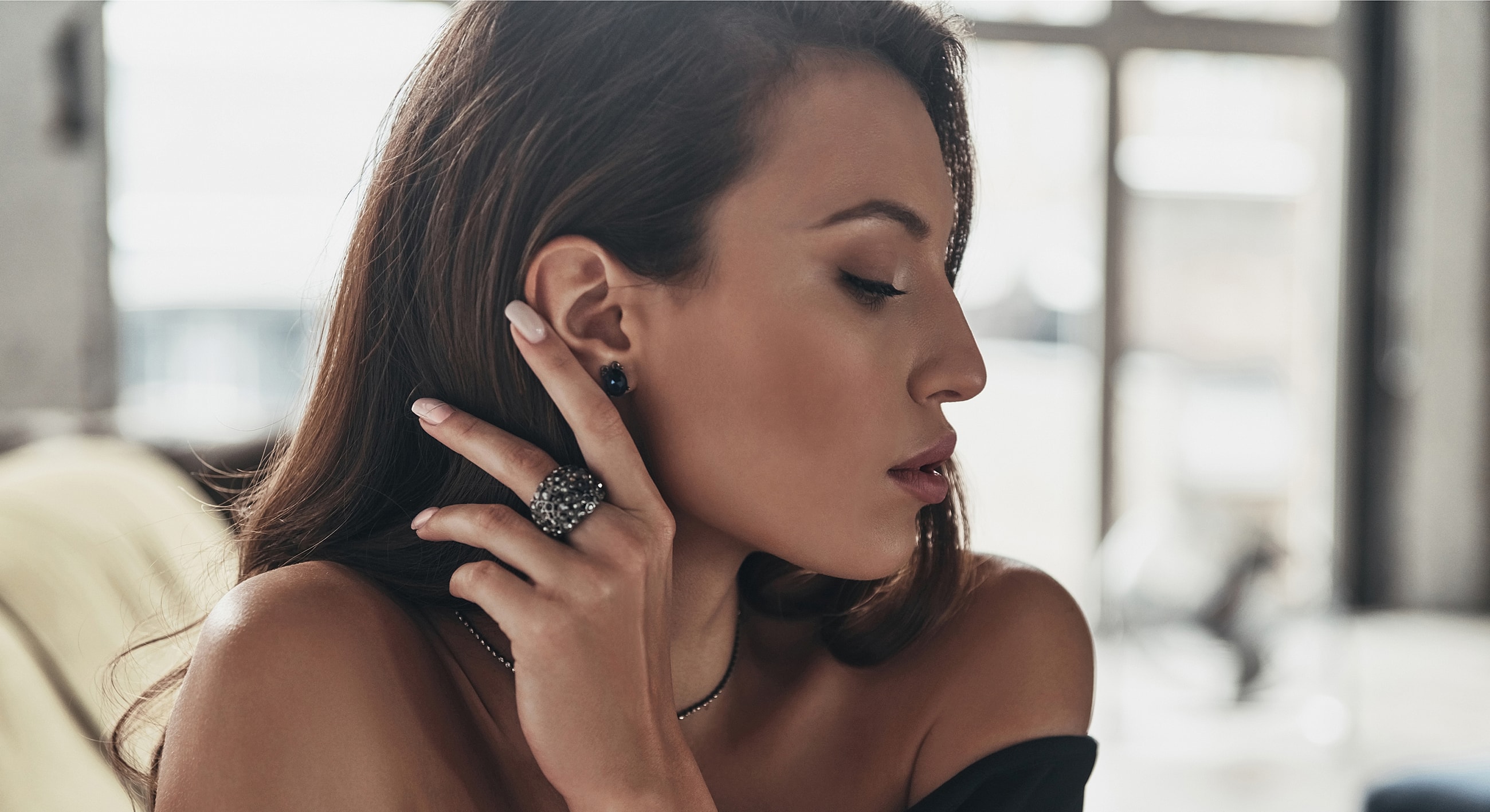 Woman wearing jewelry, profile in soft light.