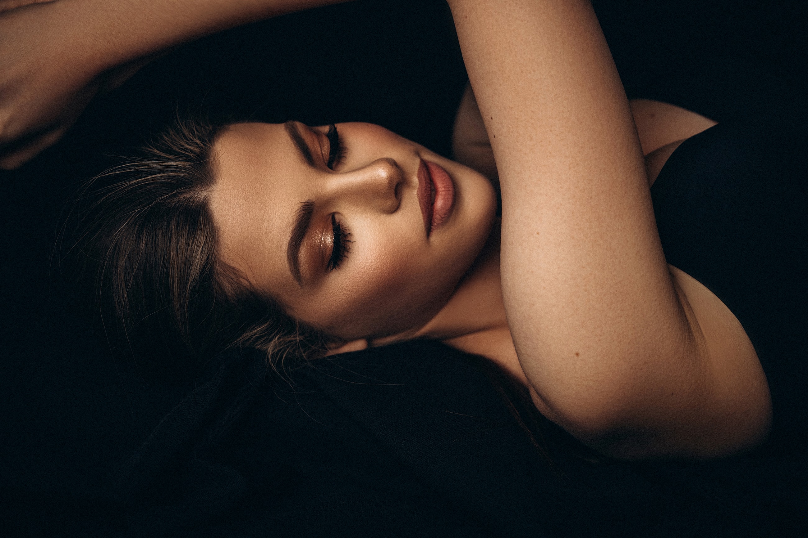 Beautiful woman with visible cheekbones and slim cheekson dark background.